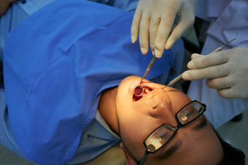 Dentist examining patient's teeth