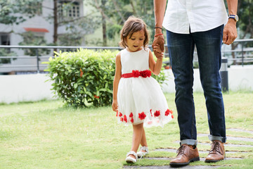 Little girl walking with father outdoors