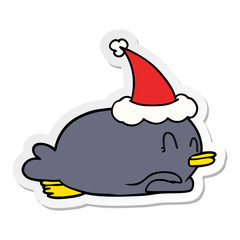 penguin lying on belly wearing santa hat
