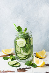 Detox water for healthy lifestyle. Fresh water in jar with lemon, cucumber and mint on wooden table. Copy space