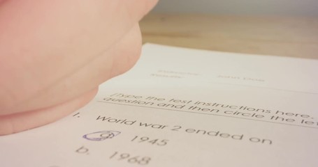 Tracking macro shot of pen marking answers in a history test in school