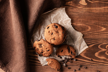 Tasty cookies with chocolate chips on wooden table