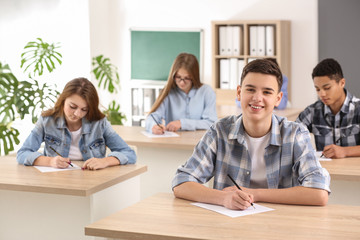 Fototapeta premium Pupils passing school test in classroom