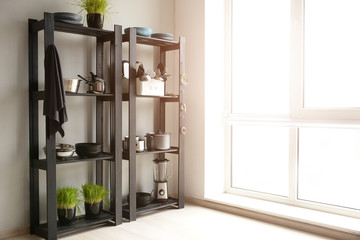 Set of clean kitchenware and utensils on shelves in kitchen