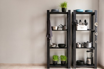 Set of clean kitchenware and utensils on shelves in kitchen