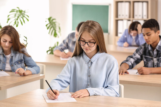 Pupils passing school test in classroom