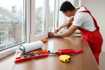 Worker installing window in flat