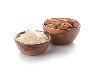 Bowls with almonds and flour on white background