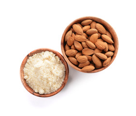 Bowls with almonds and flour on white background