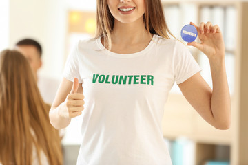 Young female volunteer with badge at meeting