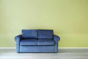 Comfortable sofa near color wall