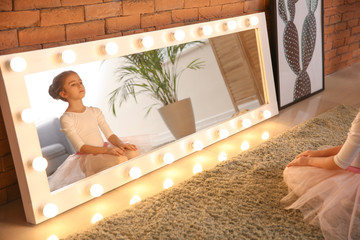 Cute little ballerina sitting in front of mirror at home © Pixel-Shot
