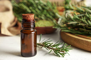 Bottle with rosemary oil on table