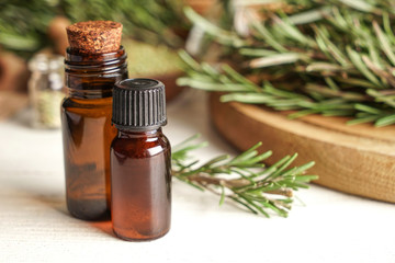 Bottles with rosemary oil on table