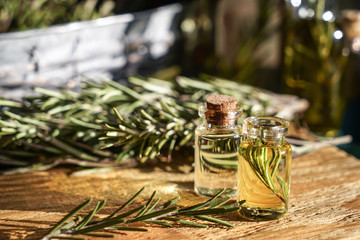 Bottles with rosemary oil on table