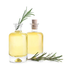 Bottles with rosemary oil on white background