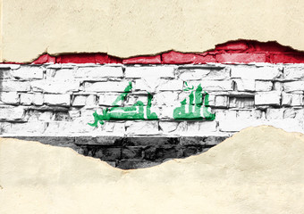 Fototapeta premium National flag of Iraq on a brick background. Brick wall with partially destroyed plaster, background or texture.