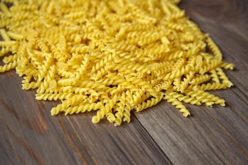 Pasta with spiral shape on brown wooden table