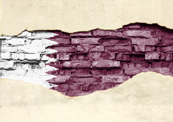National flag of Qatar on a brick background. Brick wall with partially destroyed plaster,...