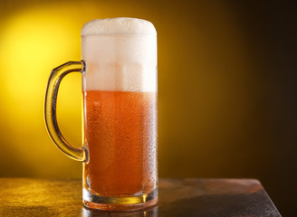 Mug of fresh beer on table