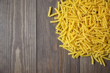 Italian spiral pasta on brown wooden table