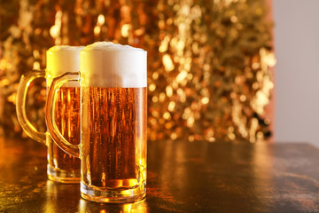 Mugs of fresh beer on table