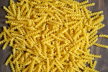 Italian spiral pasta on brown wooden table