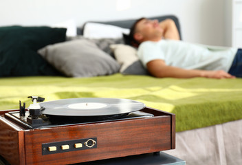 Record player in bedroom of young man
