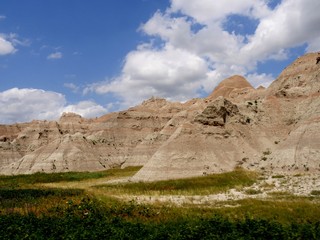 Beautiful landscape and green prairie grass at Badlands National Park in South Dakota, USA, with gorgeous clouds in the skies.