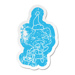 cartoon distressed sticker of a disgusted dog with christmas gift wearing santa hat