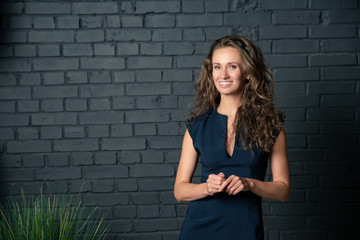 portrait of young woman in front of brick wall