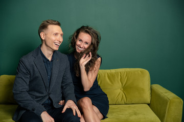 young couple sitting on sofa and watching tv