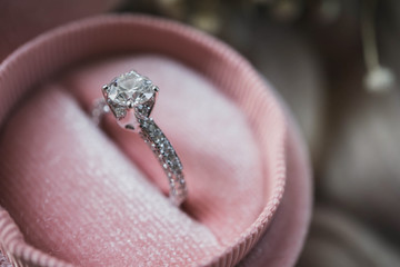 Close up of an elegant diamond ring in pink box. soft and selective focus. Love and wedding concept. - obrazy, fototapety, plakaty