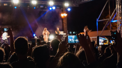 Fototapeta na wymiar Spectators of the concert are filmed on phones