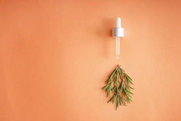 Dropper with fresh rosemary on color background
