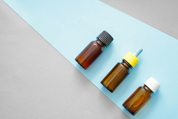 Bottles of oil on color background