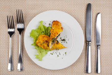 Baked stuffed chicken roll with green salad.