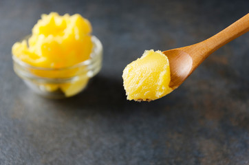 Healthy ingredient for cooking organic meal.Spoon with ghee or clarified butter,closeup