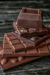 Different types of tasty chocolate on wooden table