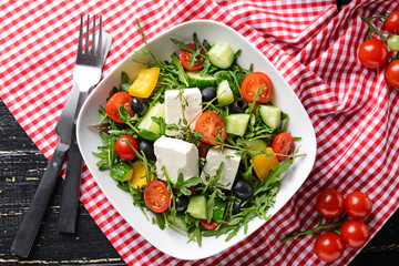 Healthy salad with feta cheese on table