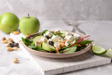 Healthy salad with feta cheese on grey table