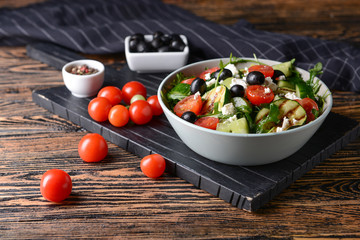 Healthy salad with feta cheese on wooden table