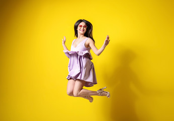 Fototapeta na wymiar Beautiful jumping woman against color background