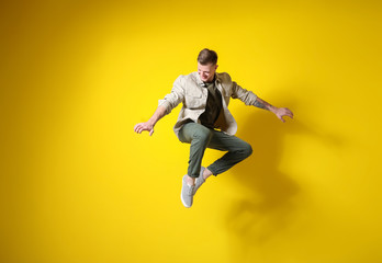Obraz na płótnie Canvas Handsome jumping man against color background