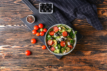 Healthy salad with feta cheese on wooden table