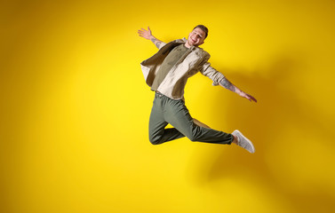Plakat Handsome jumping man against color background