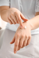 Young woman applying hand cream, closeup
