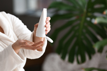 Young woman applying hand cream at home