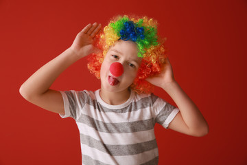 Little boy in funny disguise on color background. April fools' day celebration