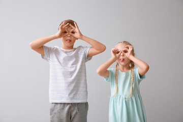 Funny grimacing little children on light background